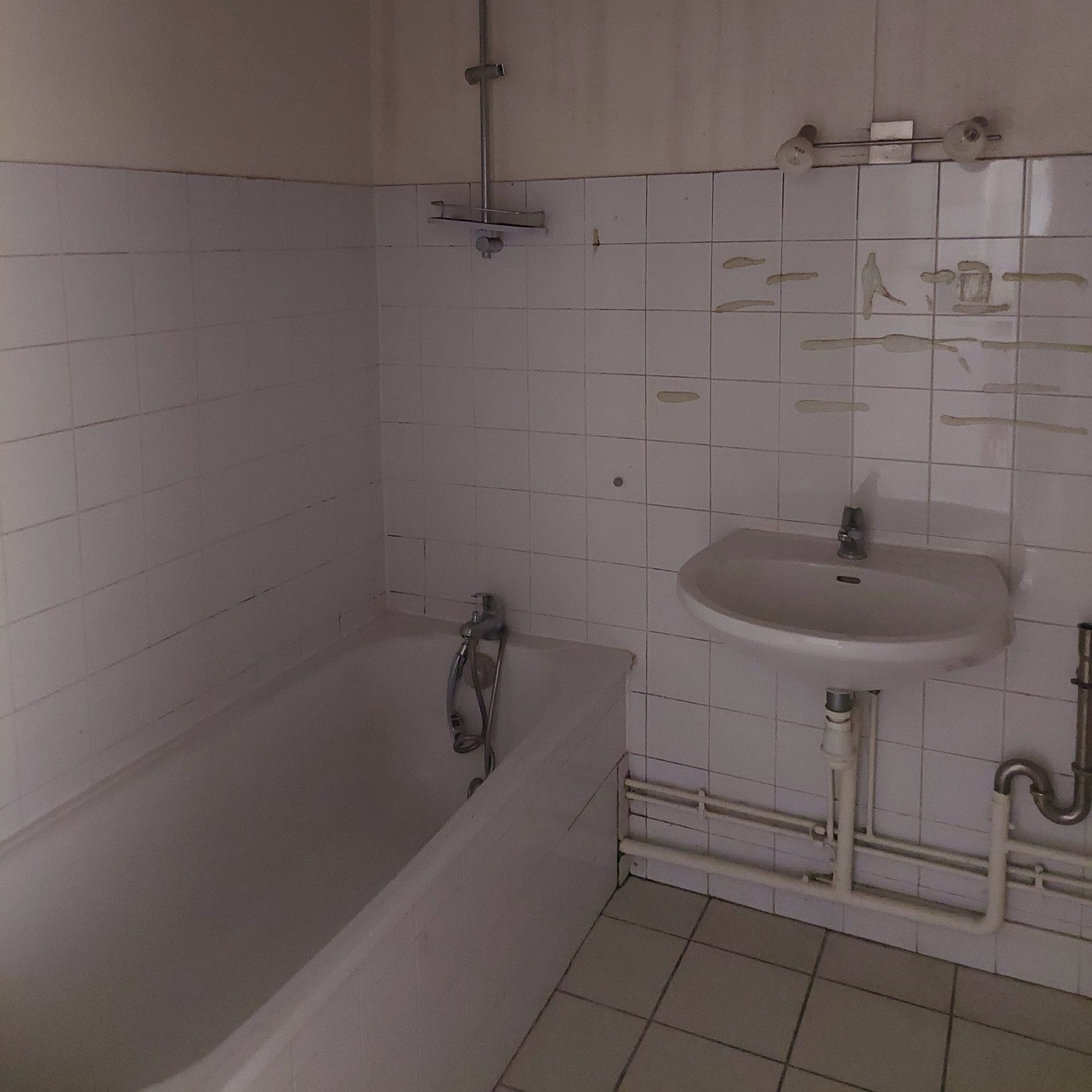 Salle de bain avant travaux, ventilation quasi inexistante et équipements datés dans un appartement à Lyon.