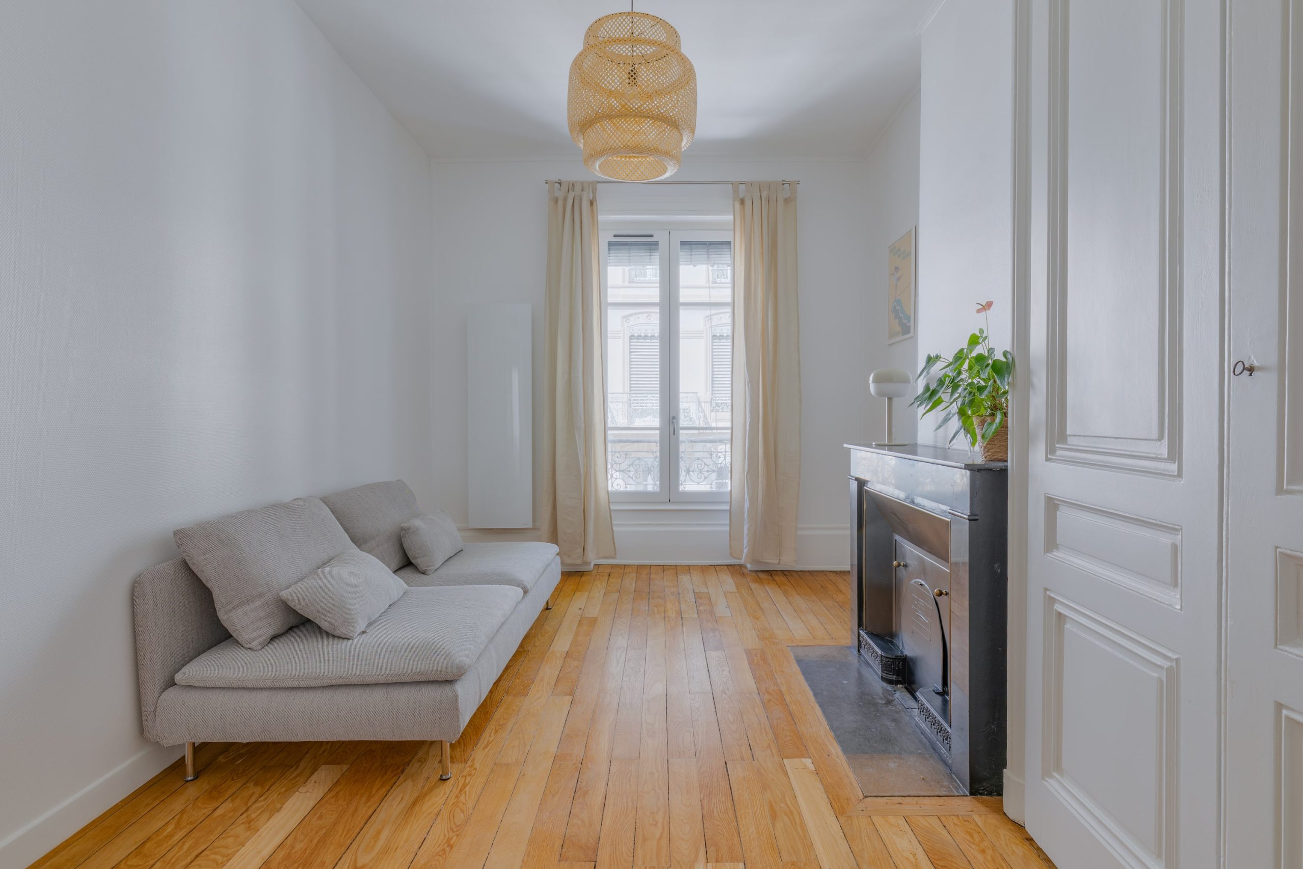 Salon rénové avec parquet et cheminée préservés, ambiance chaleureuse et menuiseries modernisées à Lyon.