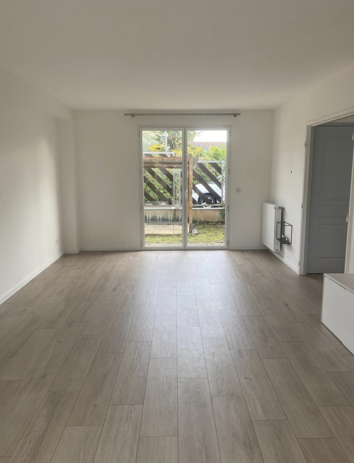 Pièce de vie avant travaux, volumes lumineux mais sans structure visuelle ni caractère dans un appartement à Tassin.